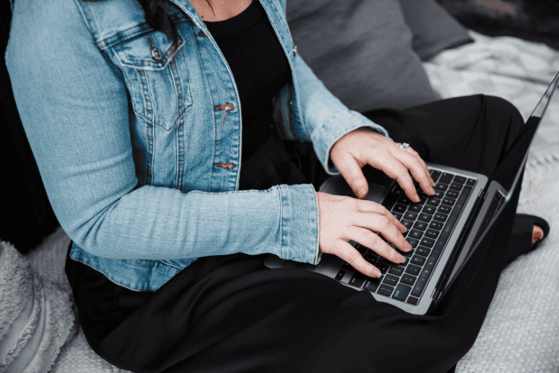 Woman sitting at a laptop feeling social media fatigue